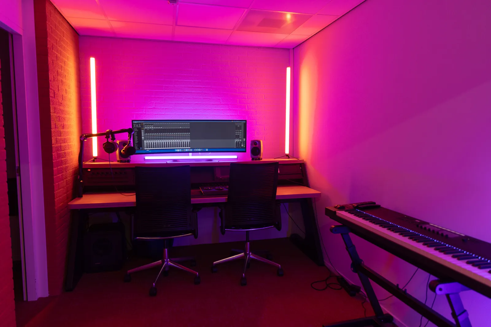 Edit bay workstation with curved monitor and studio lighting