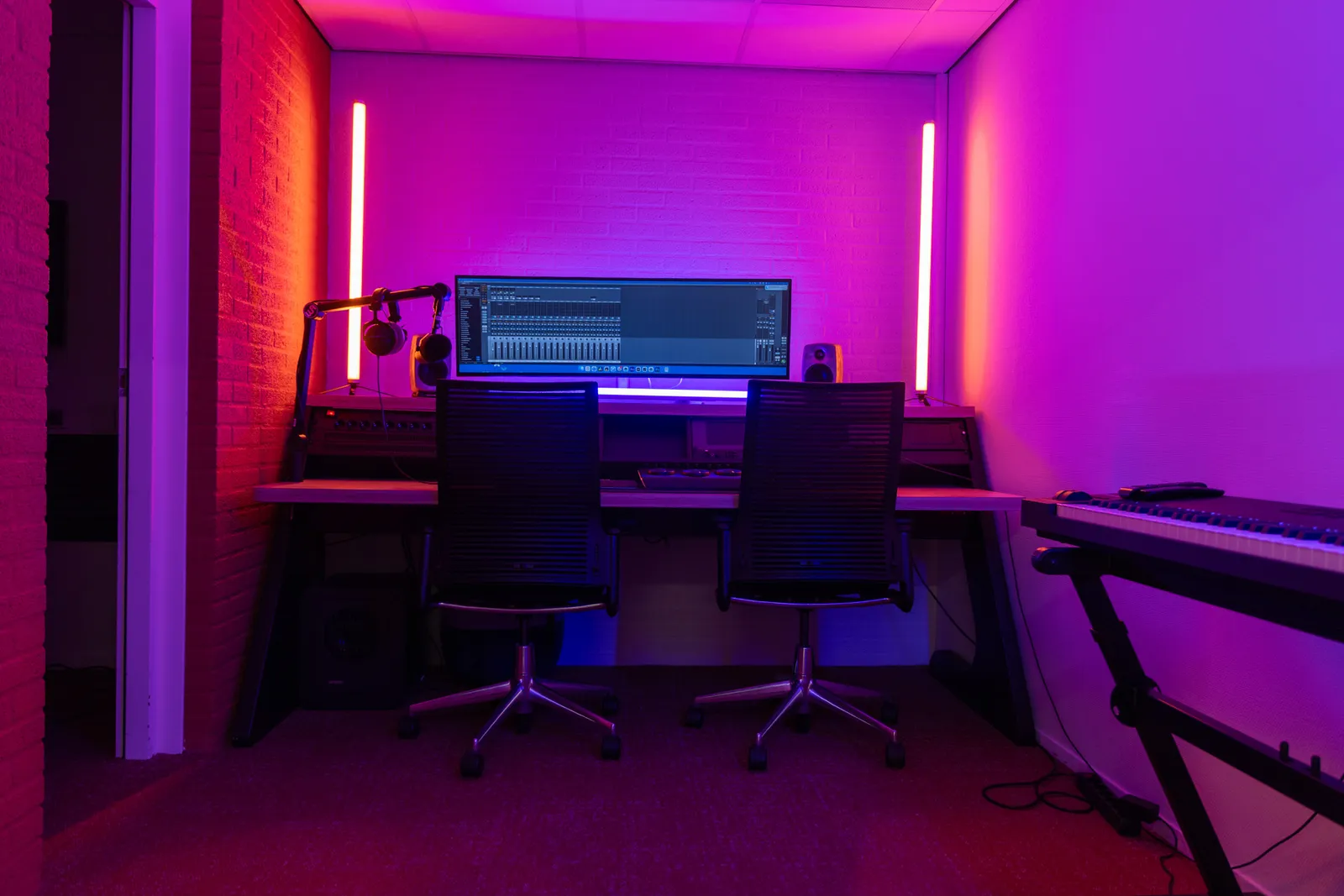 Edit bay desk with DAW mixer view, red lighting