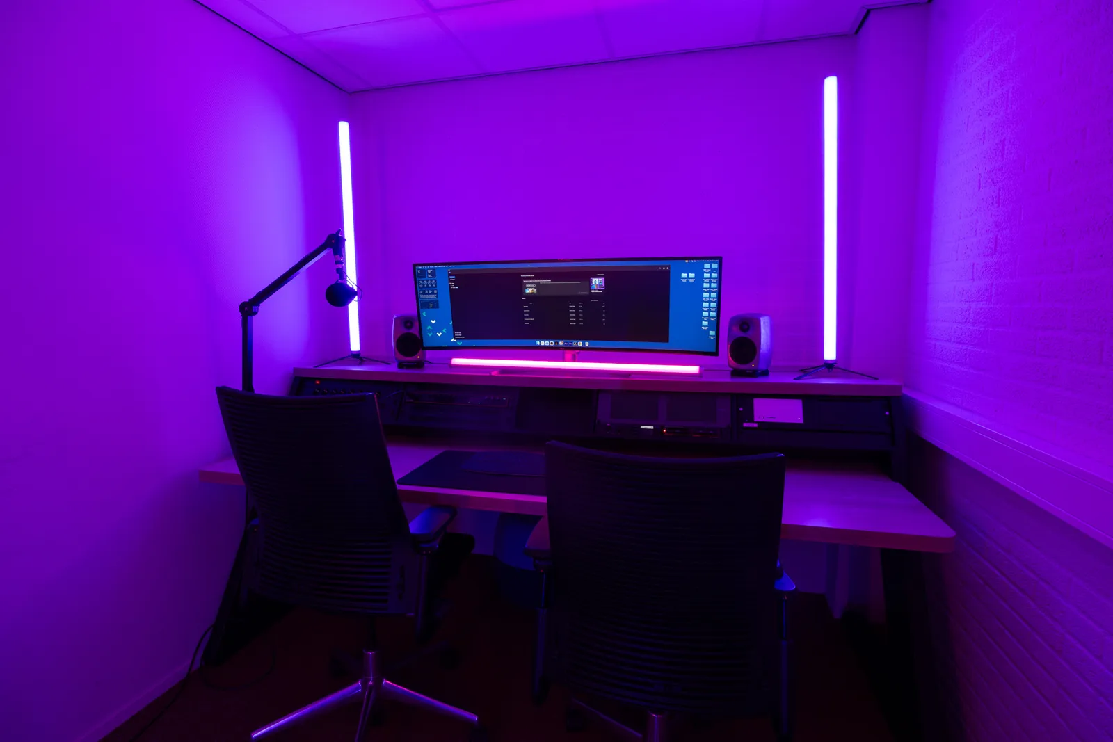 Edit bay desk with microphone arm, purple lighting