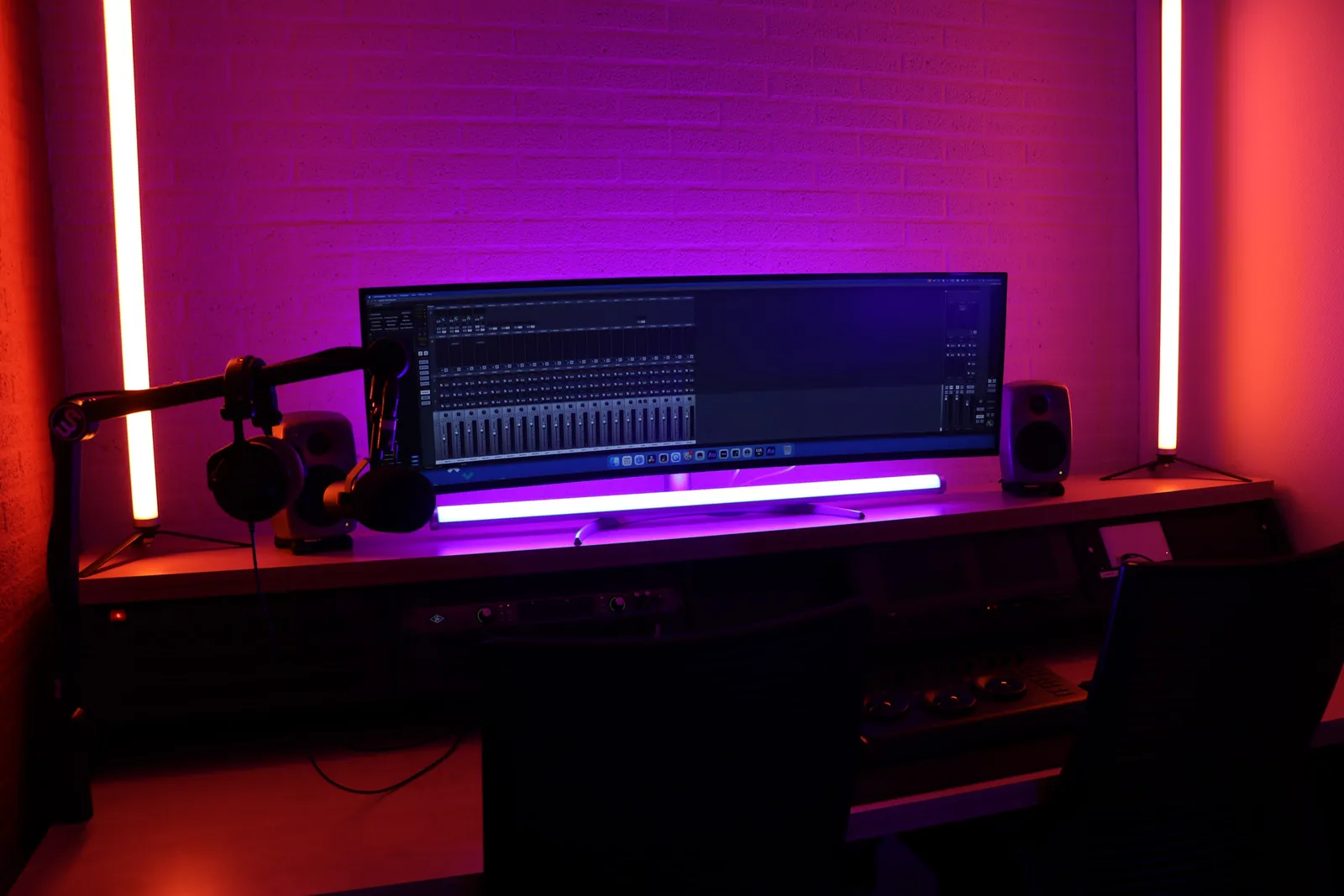 Edit bay desk with curved monitor, warm lighting